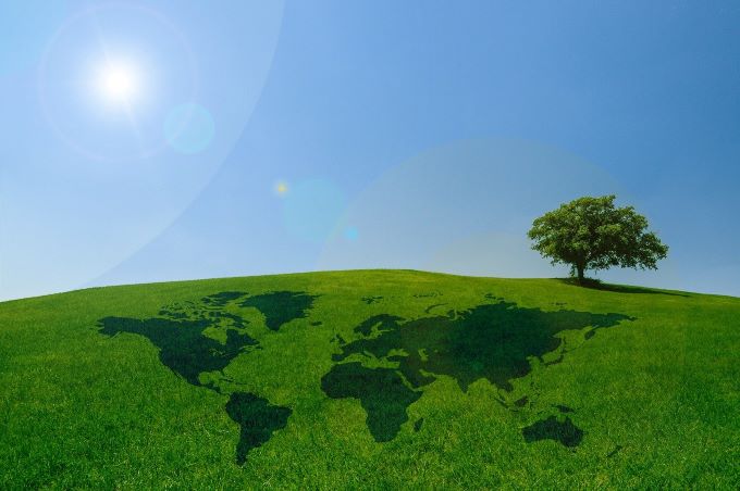 SNAS sa stal signatárom IAF MLA pre oblasť Verifikácie a Validácie. Na obrázku je na trávniku mapa sveta a strom symbolizujúce rast sveta k ekologickejším zajtrajškom.