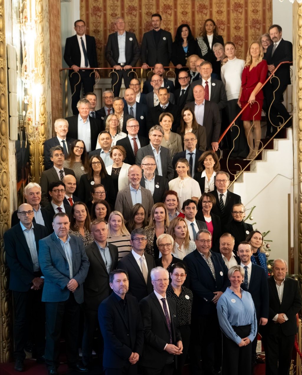 Spoločná fotografia účastníkov zasadnutia stojacich na schodisku
